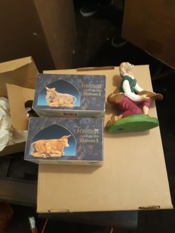 Nativity figurines including a shepherd and a cow